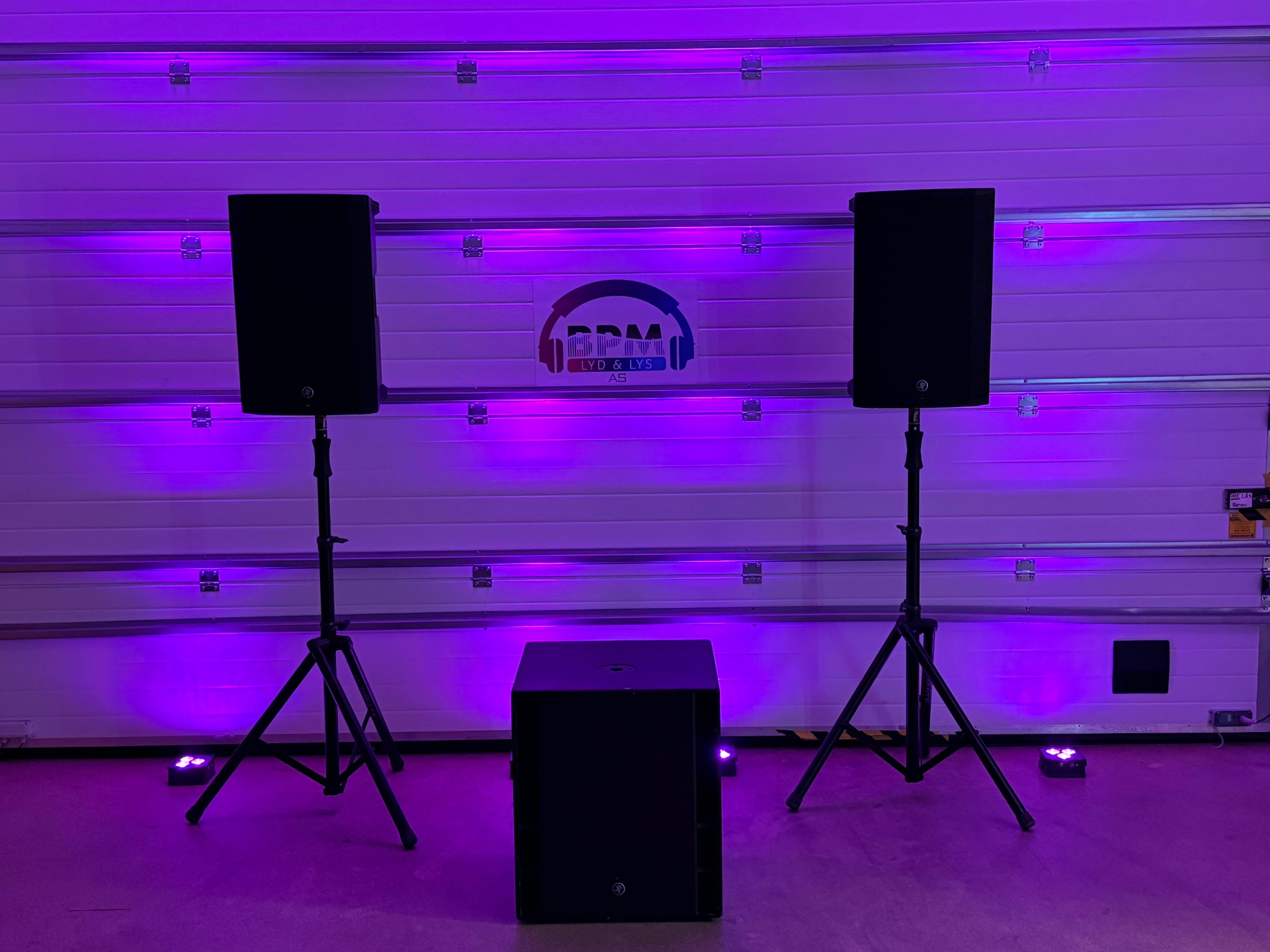 To høyttalere og én subwoofer med lilla uplights